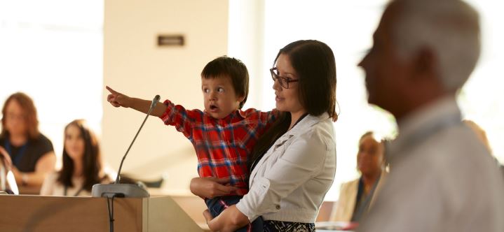 Femme et enfant prenant la parole à une audience. 