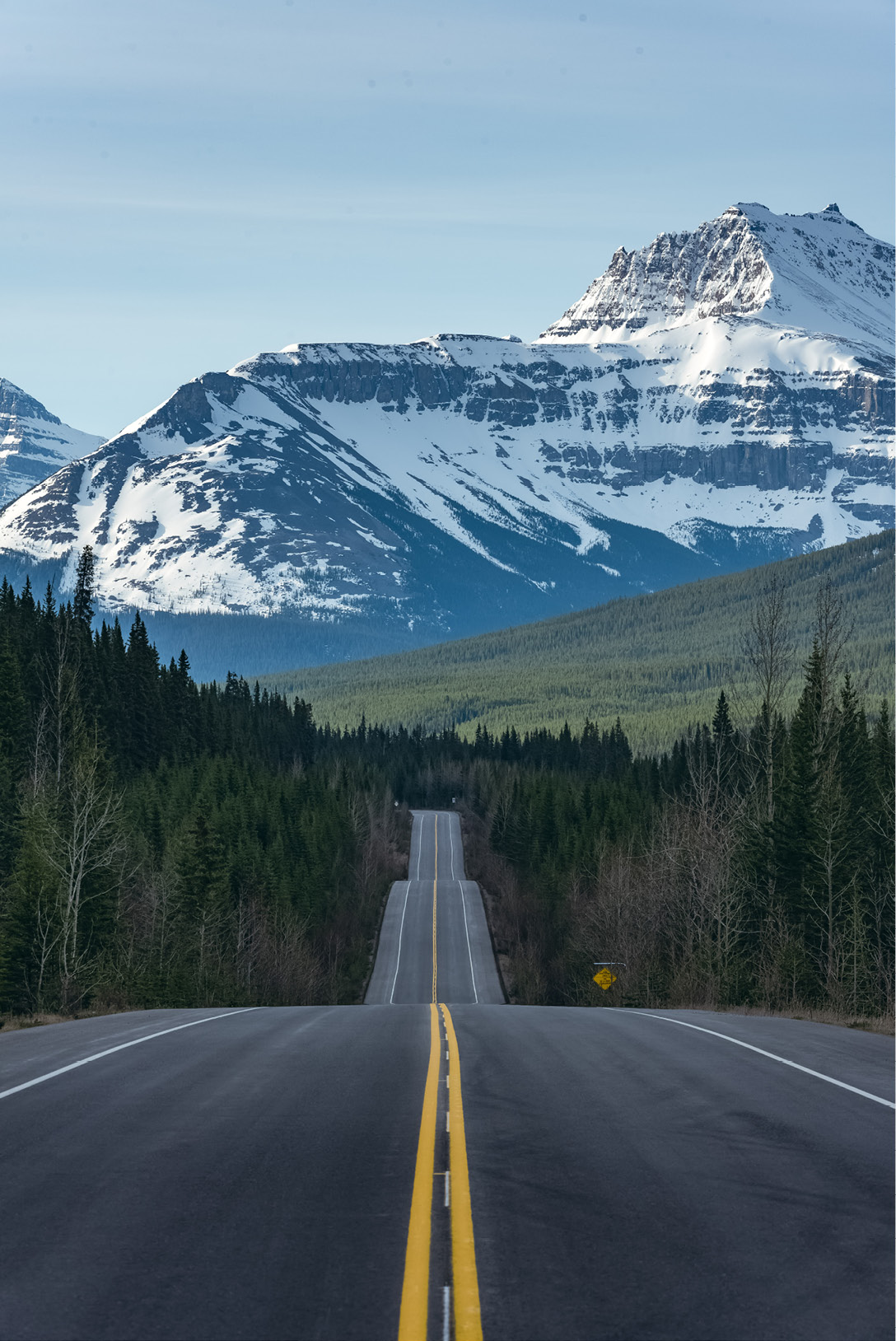 Un long tronçon de route droit menant aux montagnes