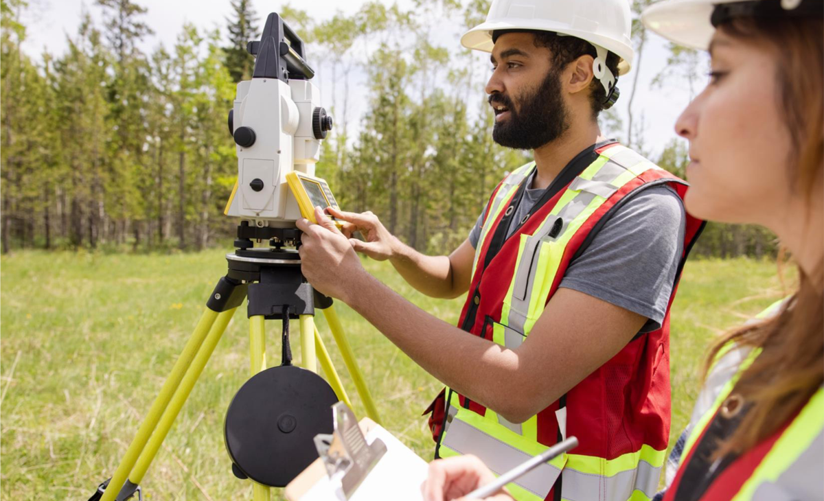Figure 5 – Surveyors using equipment to measure a field