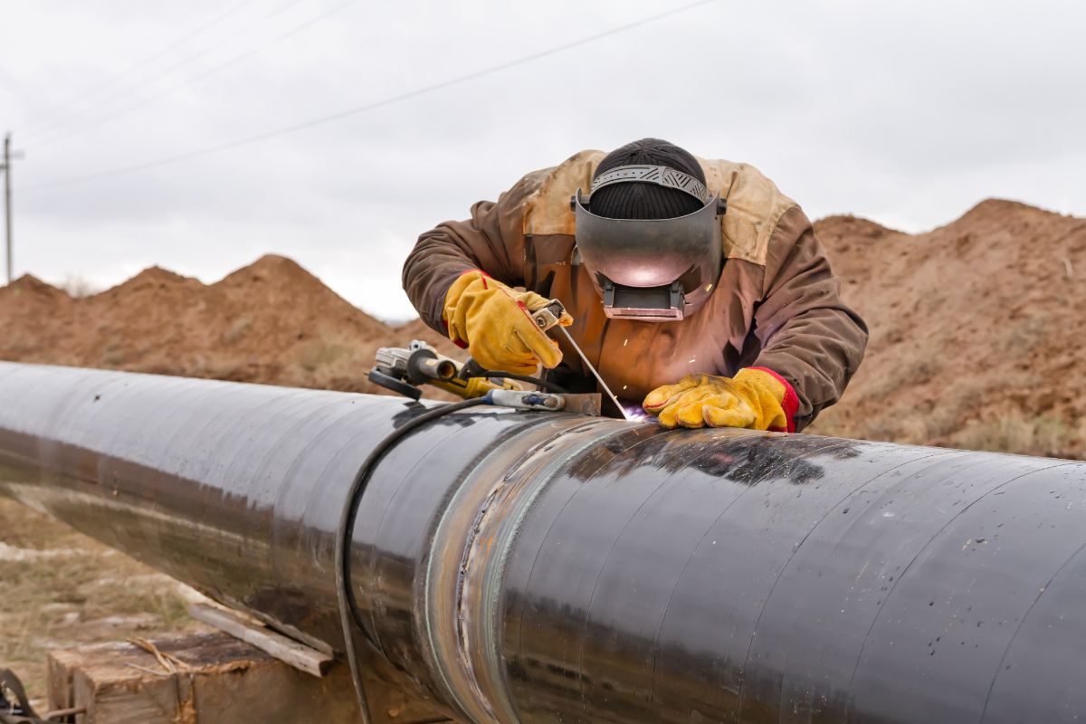 Worker welds pipeline.