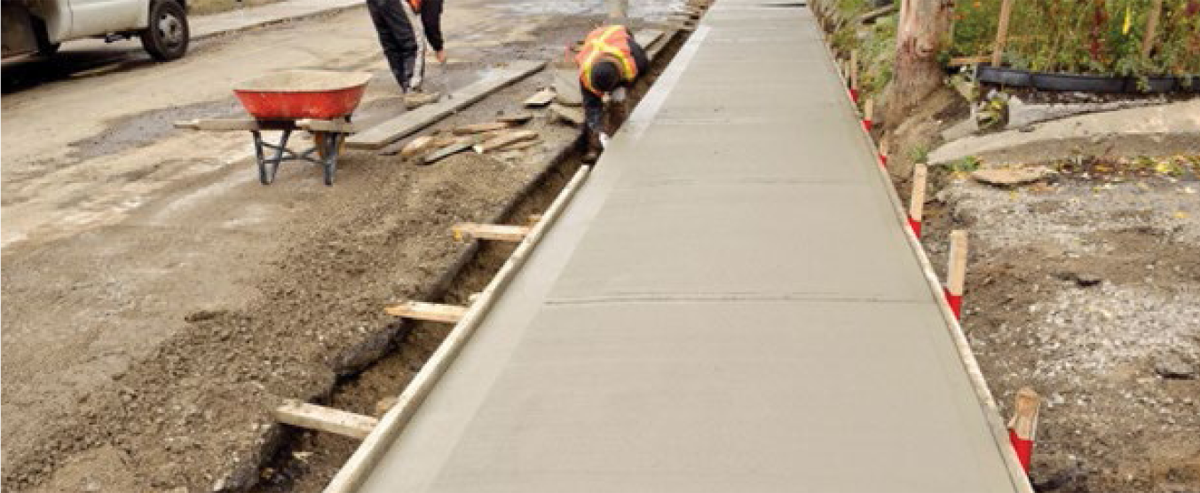 Stakes for concrete forms with marks at 29 cm on sidewalk construction
