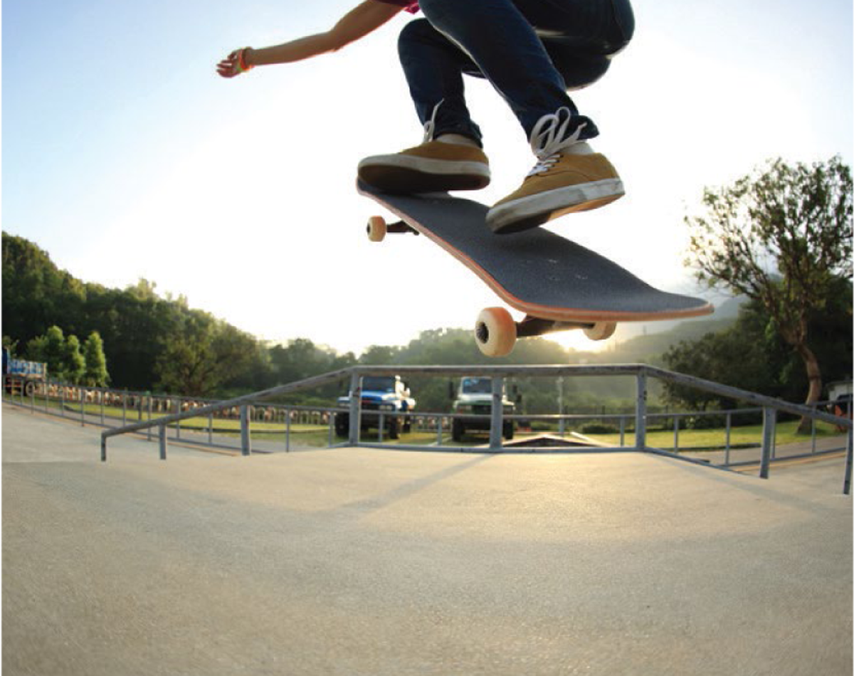 Teen on skateboard taking a jump at a skateboard park